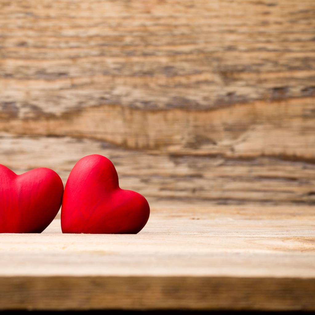 Два красных сердца лежат на деревянной лавке
