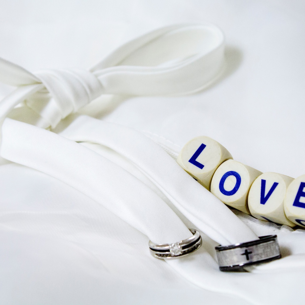 Два кольца перевязанные белой лентой и кубики с надписью любовь