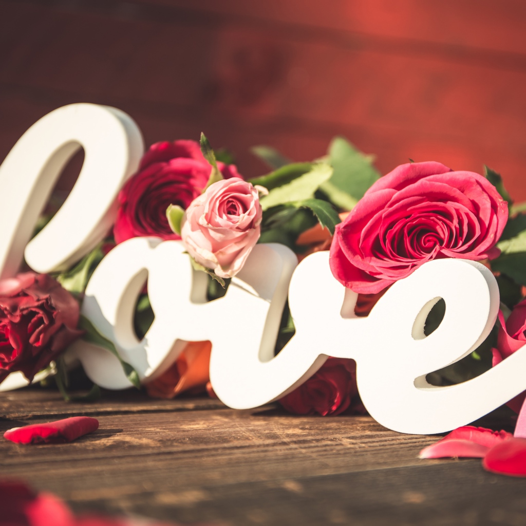 Белая надпись любовь с букетом роз