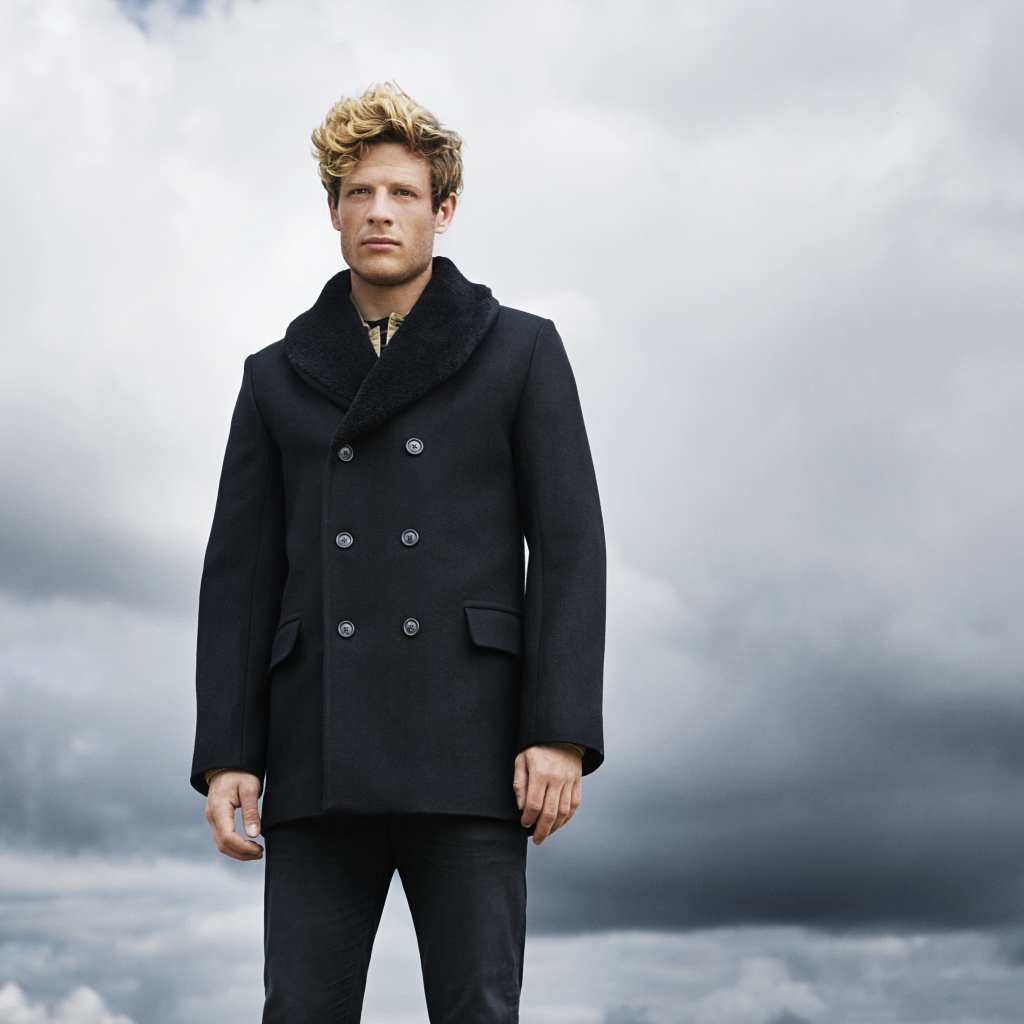 Актер Джеймс Нортон в черном пальто на фоне неба