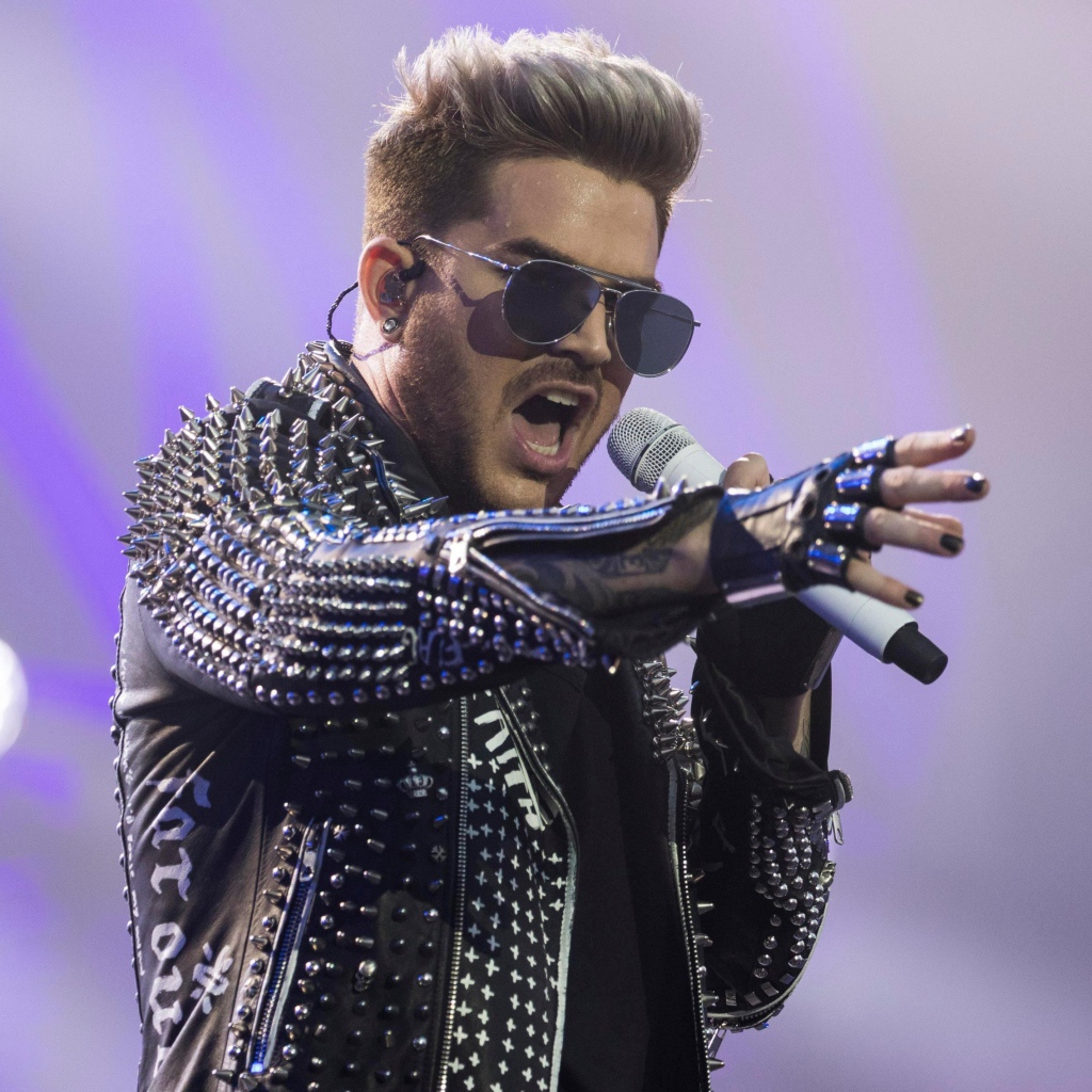 Американский певец Адам Ламберт на сцене с микрофоном