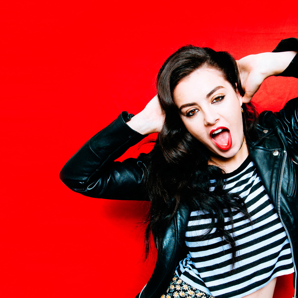 Американская певица Charli XCX позирует на красном фоне 