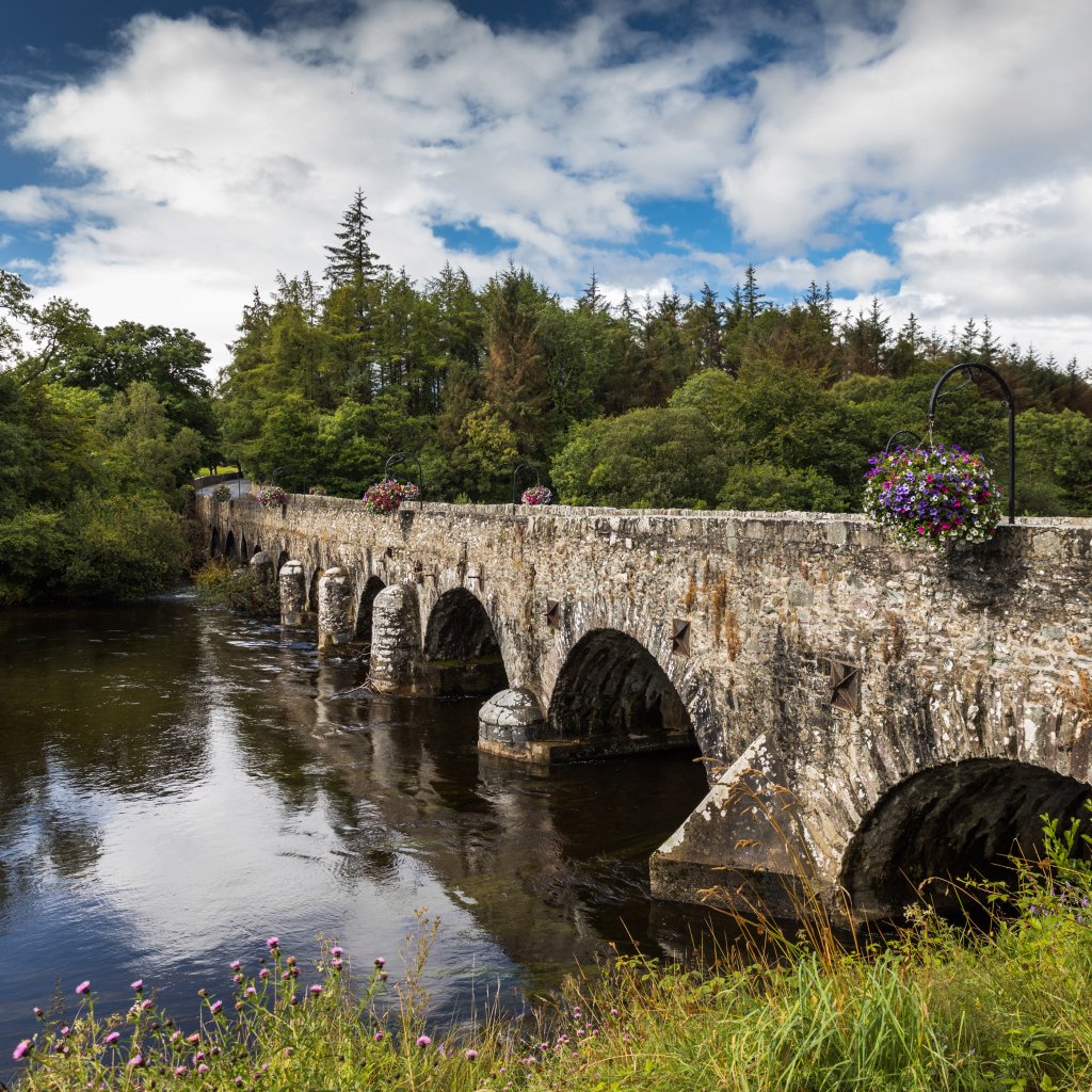 Мост через реку у леса на фоне красивого голубого неба с белыми облаками. Ирландия