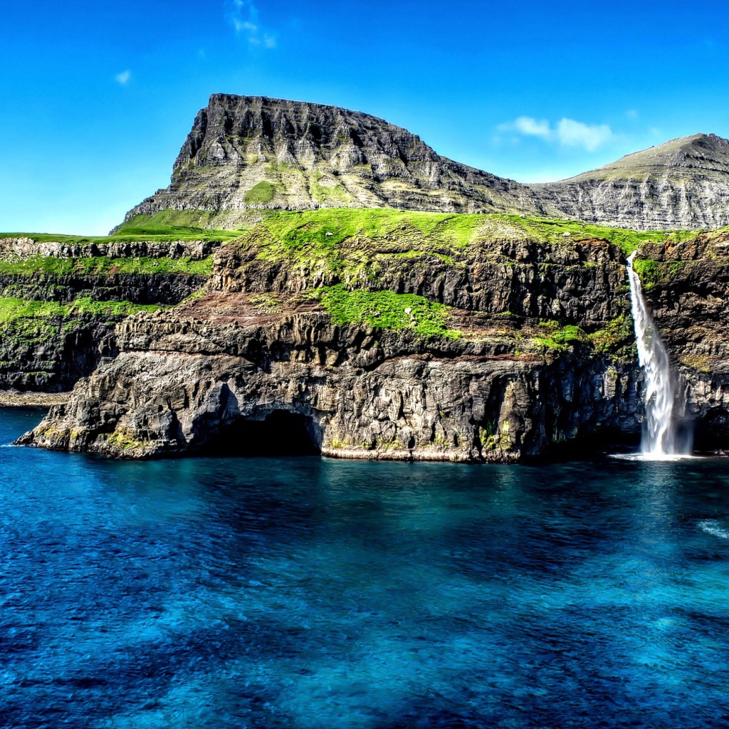 Маленький водопад стекает со скалы в океан, Гавайские острова