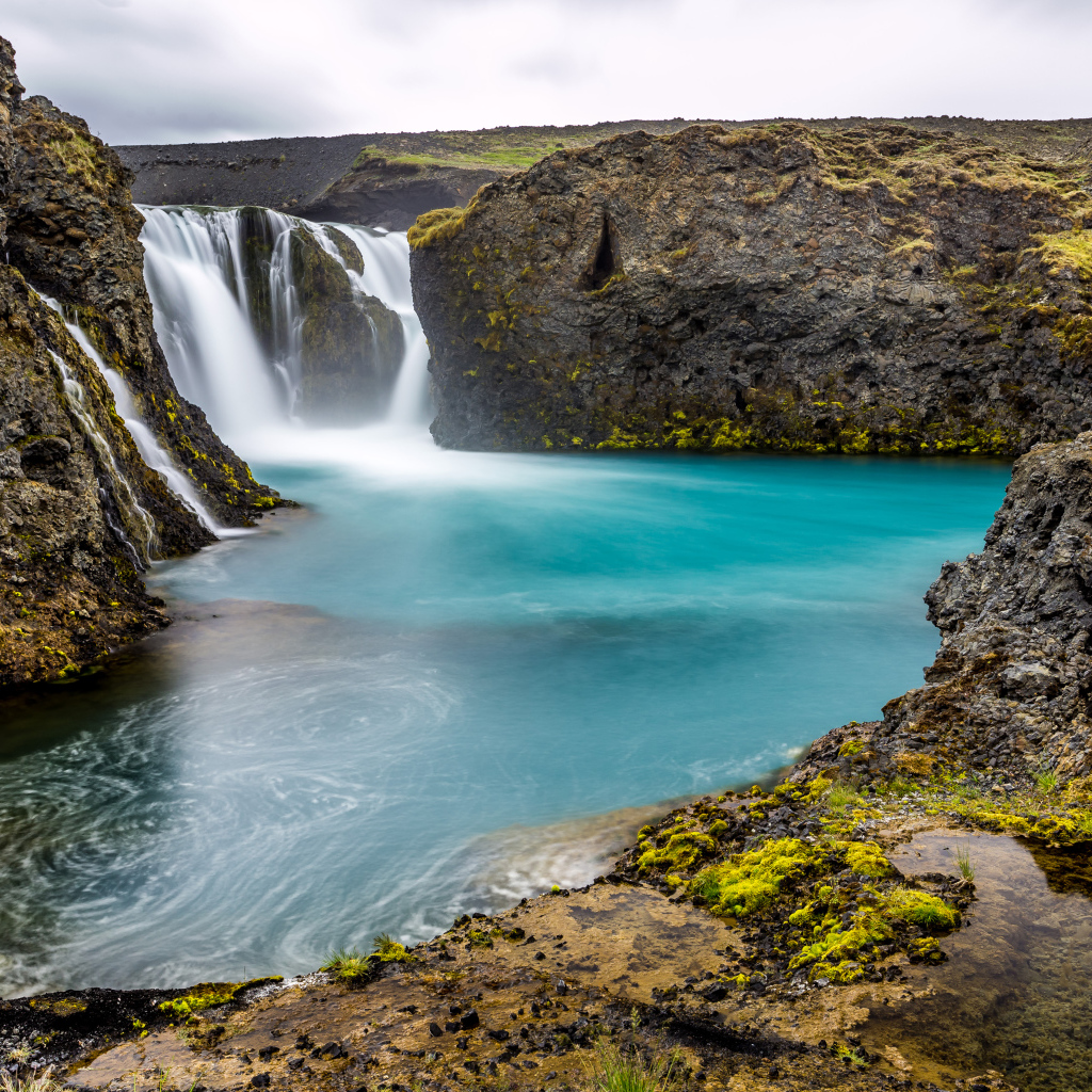 Красивый водопад между скалистых берегов 