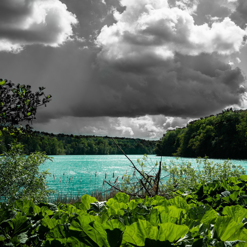 Голубая вода в озере на фоне дождевых облаков 