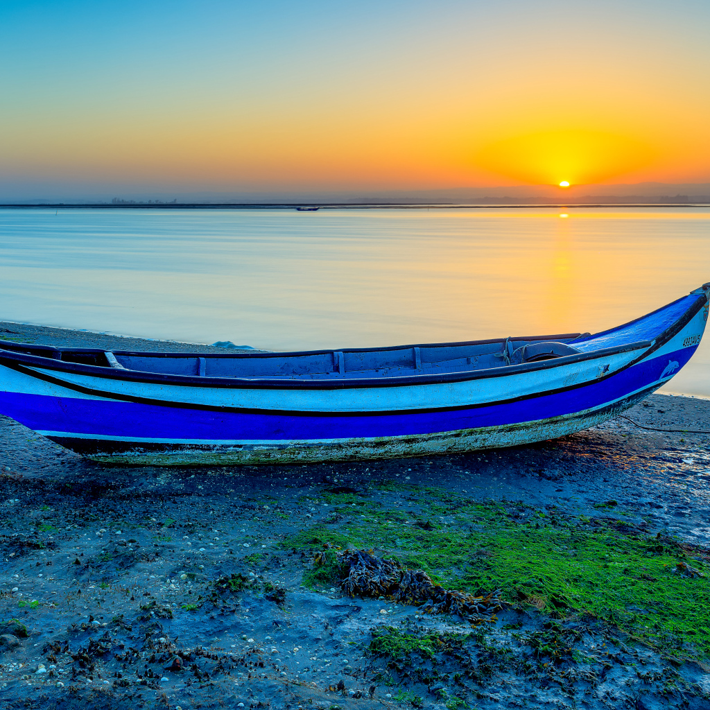 Лодка на берегу реки на закате солнца