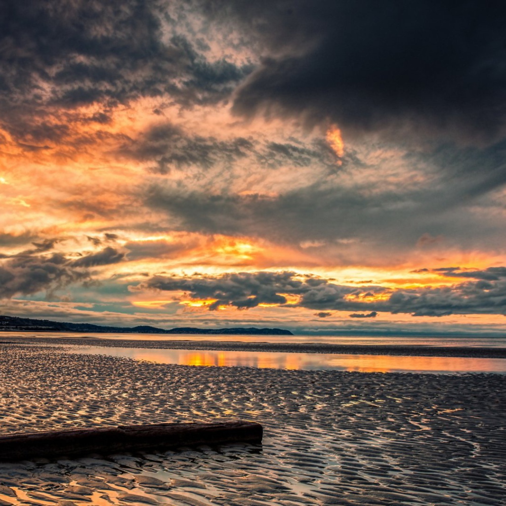 Прохладный закат в хмуром небе  над пляжем