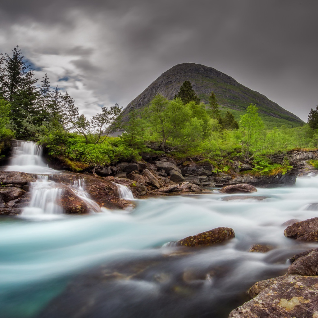 Быстрая вода в горной реке с маленьким водопадом 