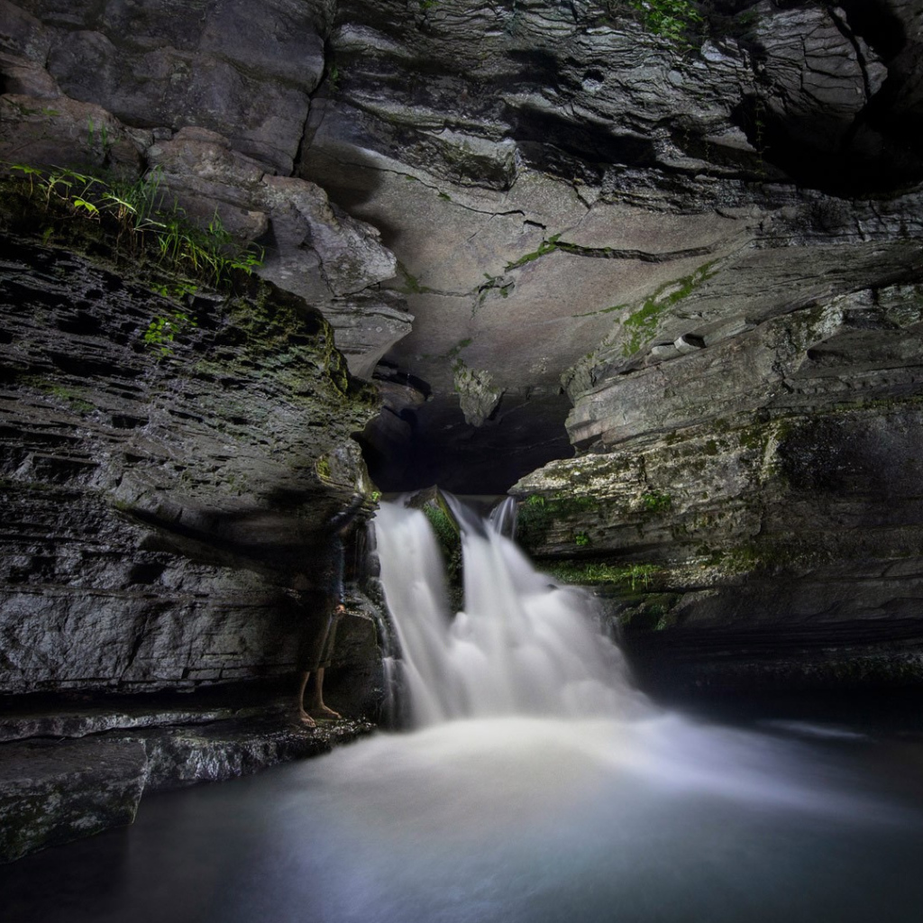 Быстрый водопад в каменной пещере 