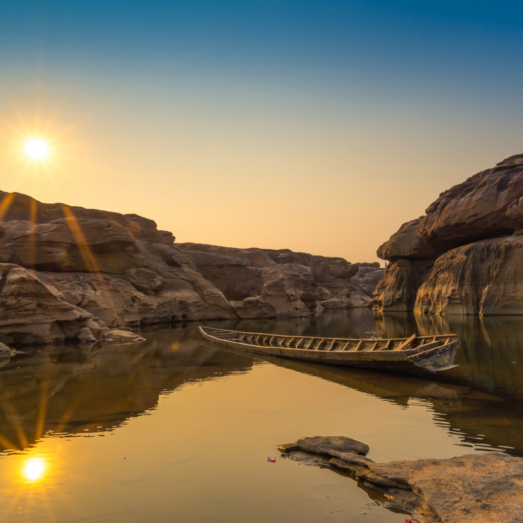 Лодна на озере между скал на рассвете