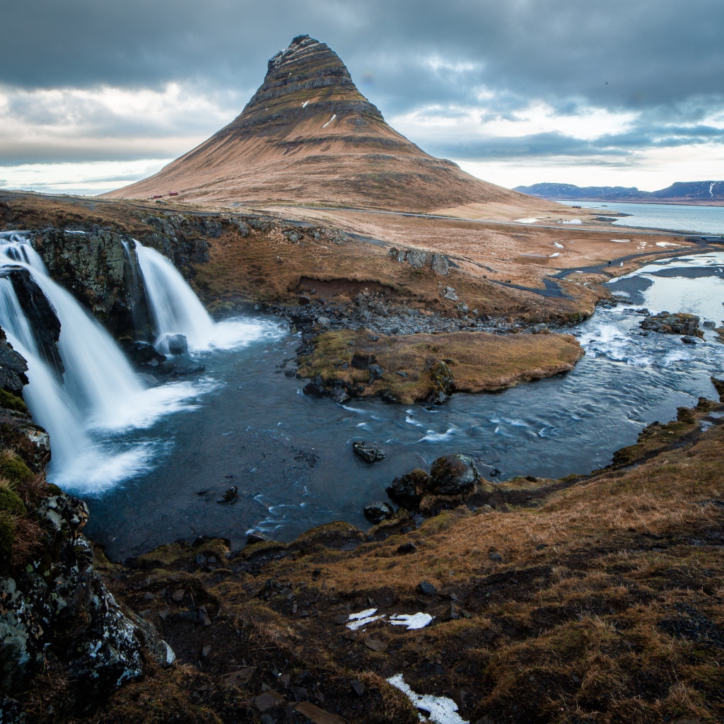Гора и водопад у реки в Исландии  