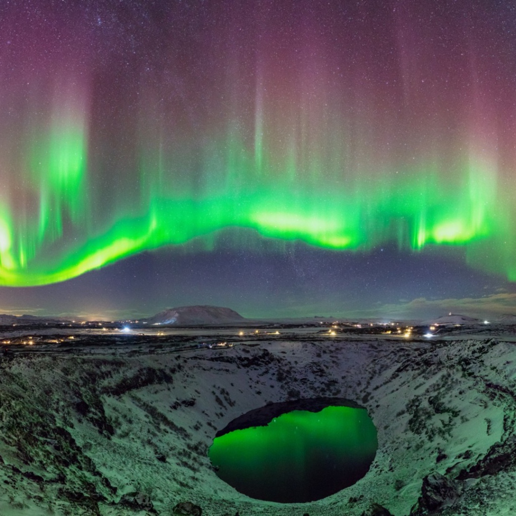 Северное сияние над заснеженным кратером вулкана 