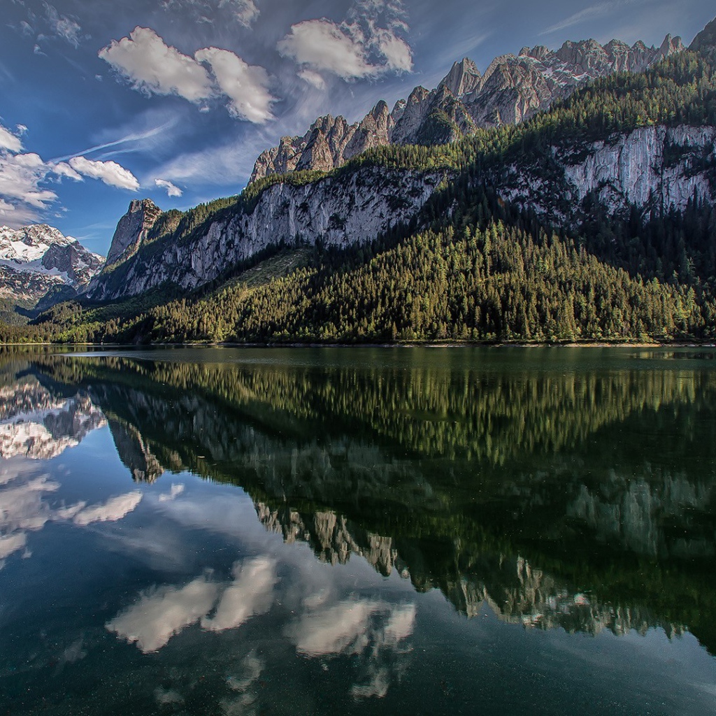 Сосны и горы отражаются в озере  