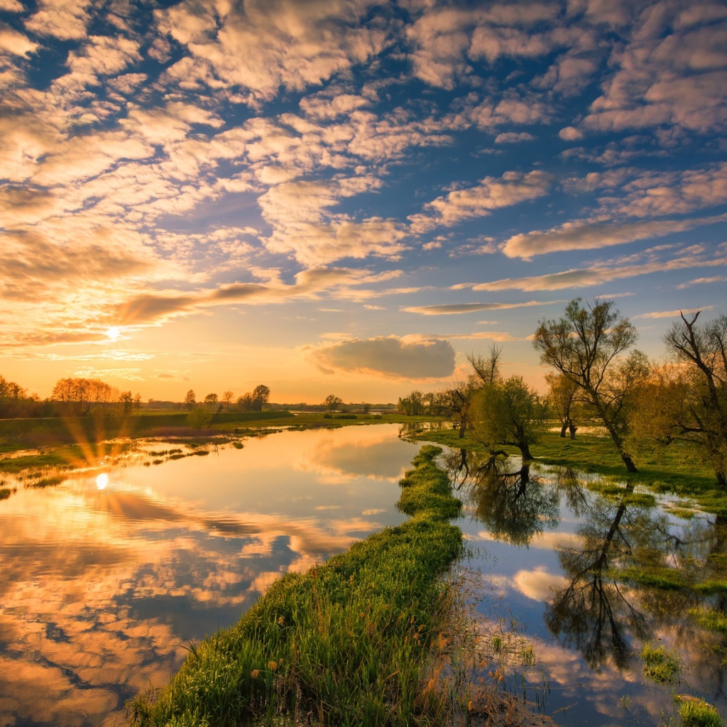 Восход солнца и облака отражаются в чистой воде реки 