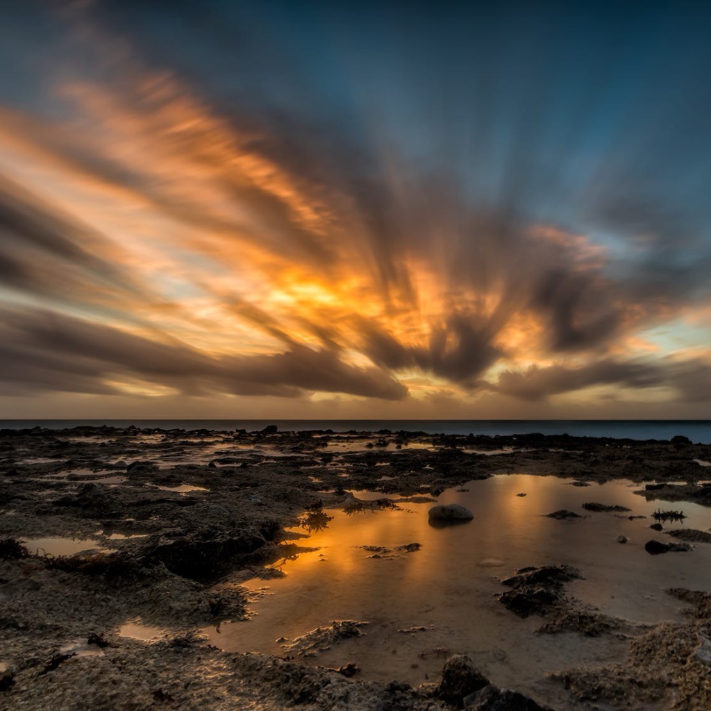 Закат солнца в облаках над водой 