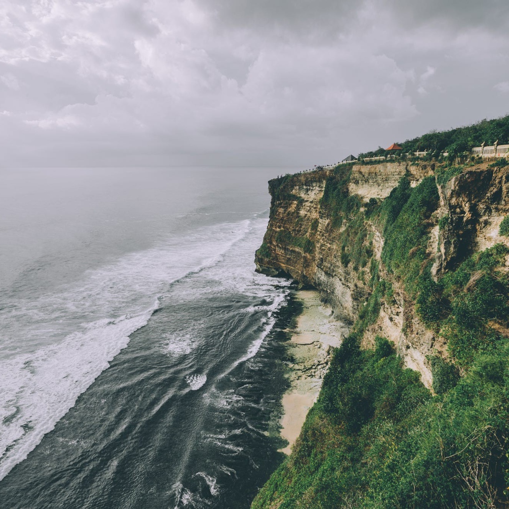 Бушующие волны у зеленого утеса 