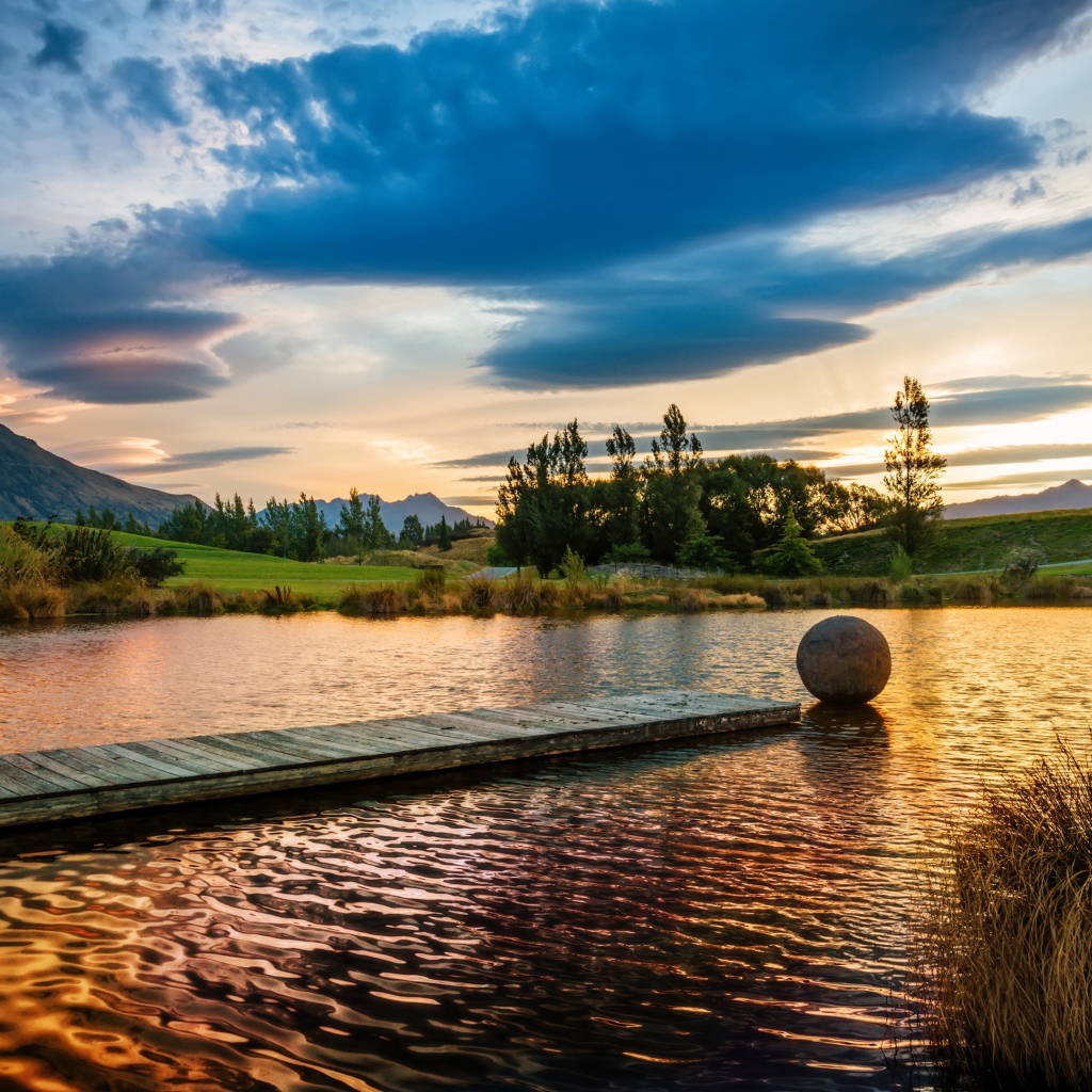 Деревянный мост в озере на закате солнца