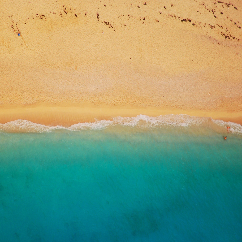 Желтый песок соединяется с голубой водой 
