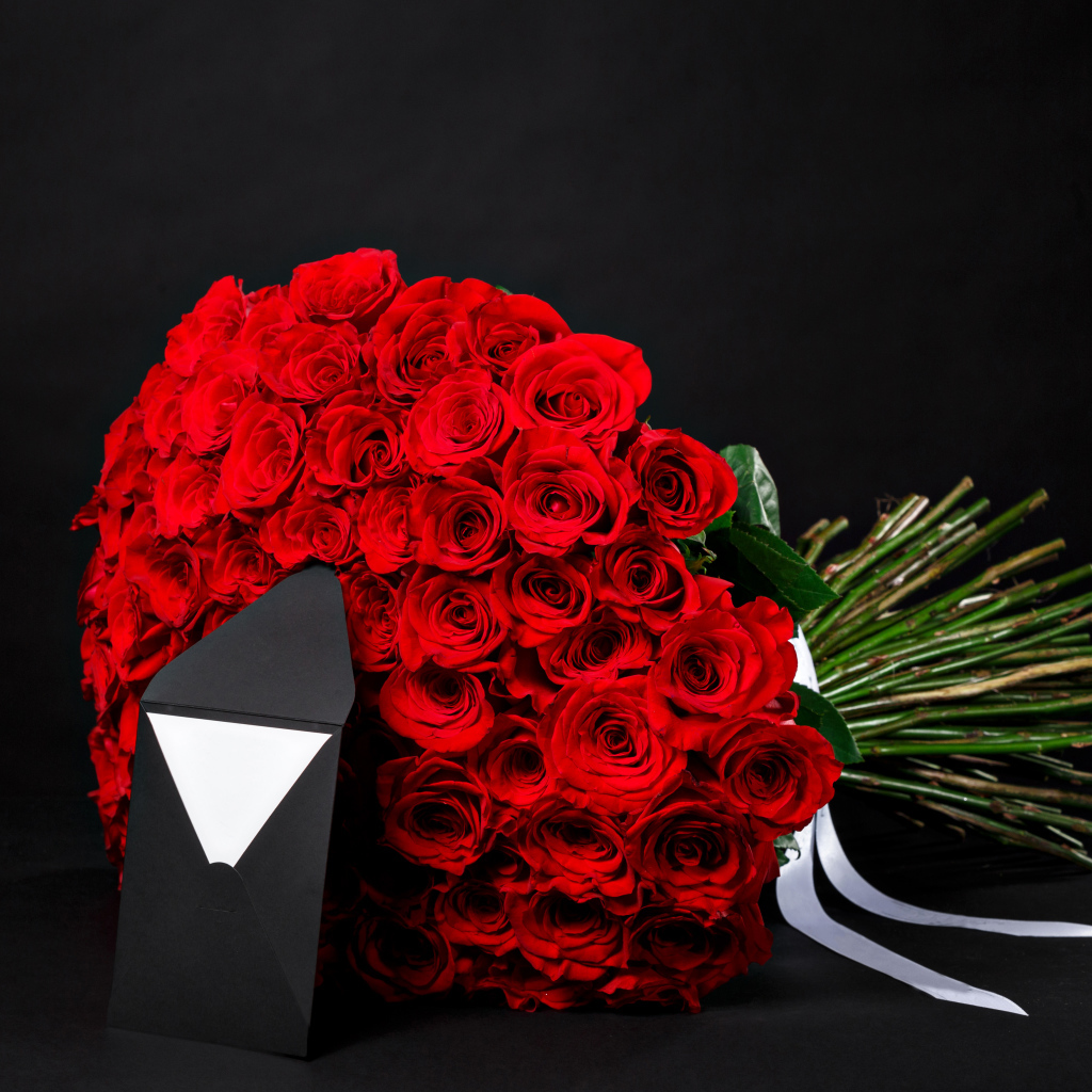 Большой букет красных роз с конвертом на черном фоне
