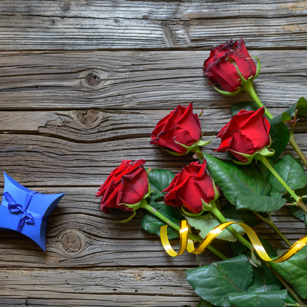 Букет красных роз на столе с синей коробочкой