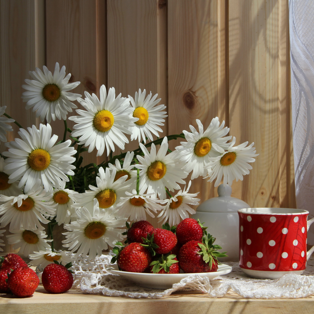 Букет белых ромашек на столе с клубникой