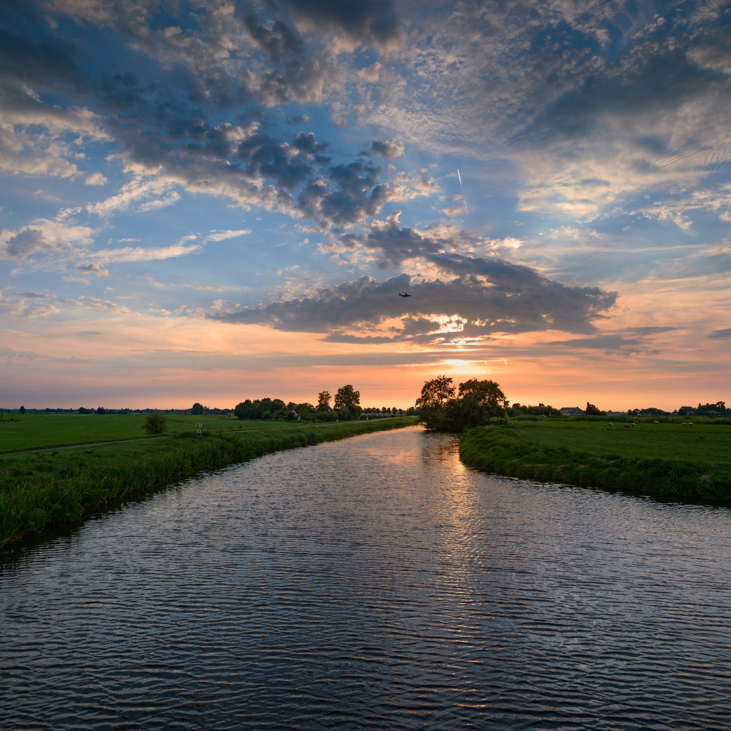 Закат солнца в облаках  над спокойной рекой