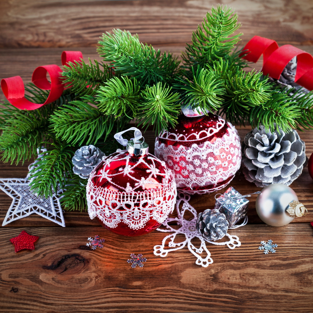 Красивые елочные игрушки с зеленой еловой веткой на деревянном столе 