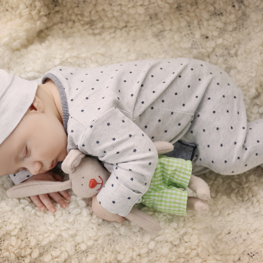 Грудной ребенок спит с любимой мягкой игрушкой