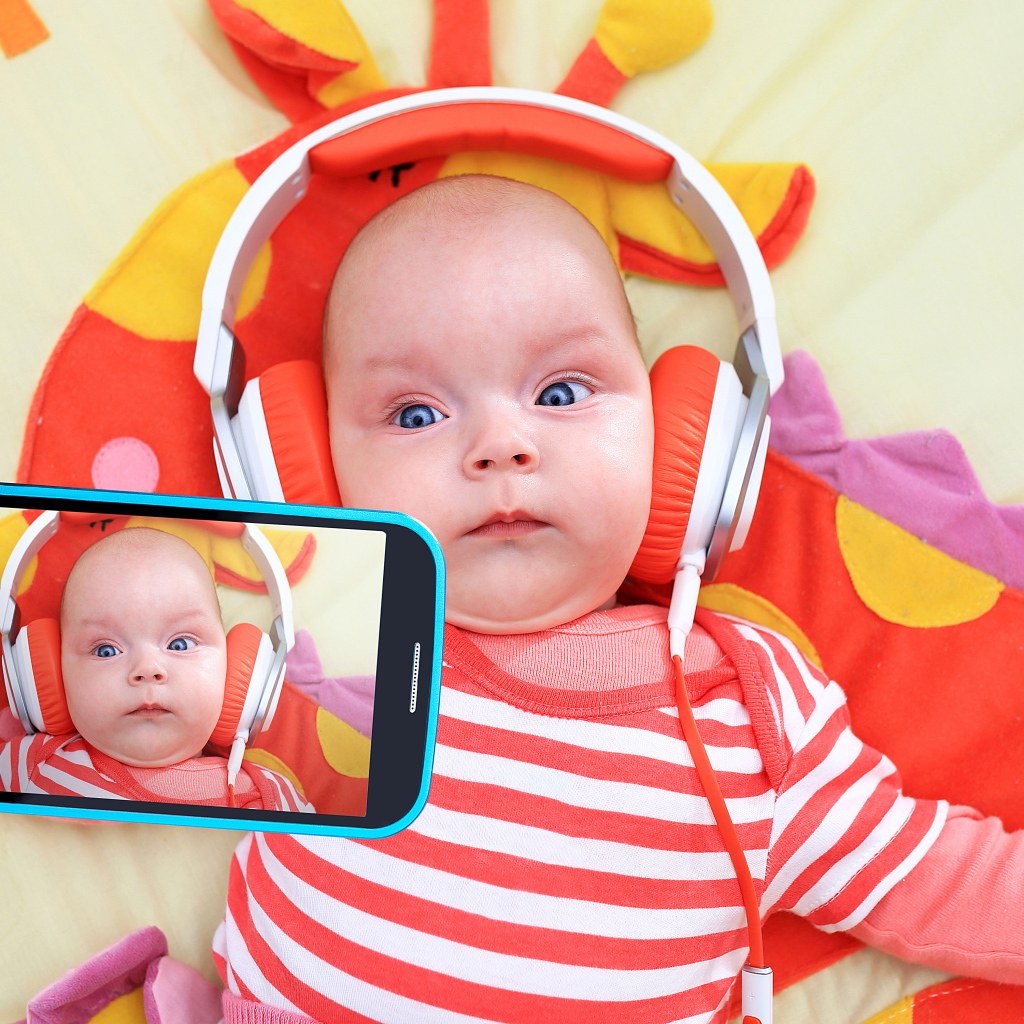 Младенец в оранжевых наушниках делает селфи