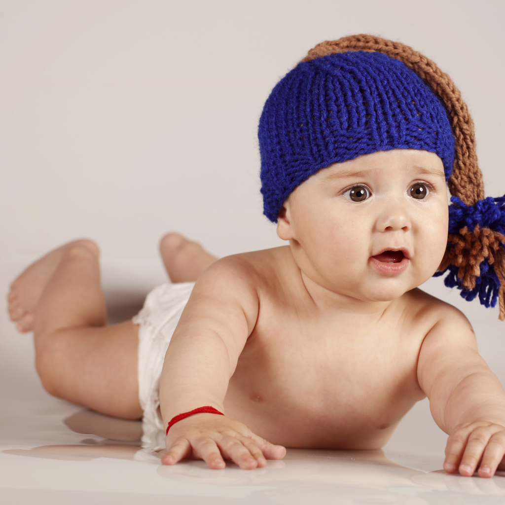Грудной кареглазый ребенок в вязаной шерстяной шапке