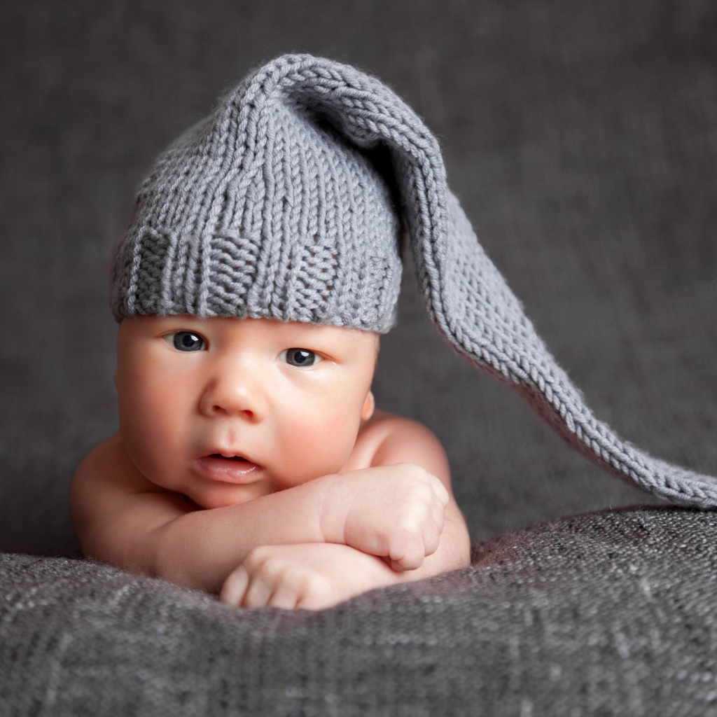 Милый младенец в большой серой вязаной шапке