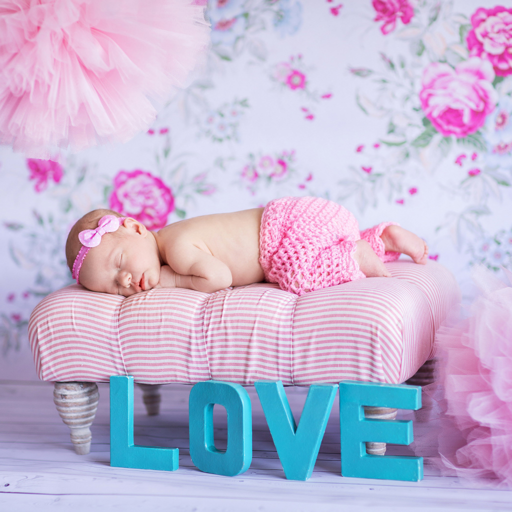 Спящий грудной ребенок в розовом костюме и надписью love