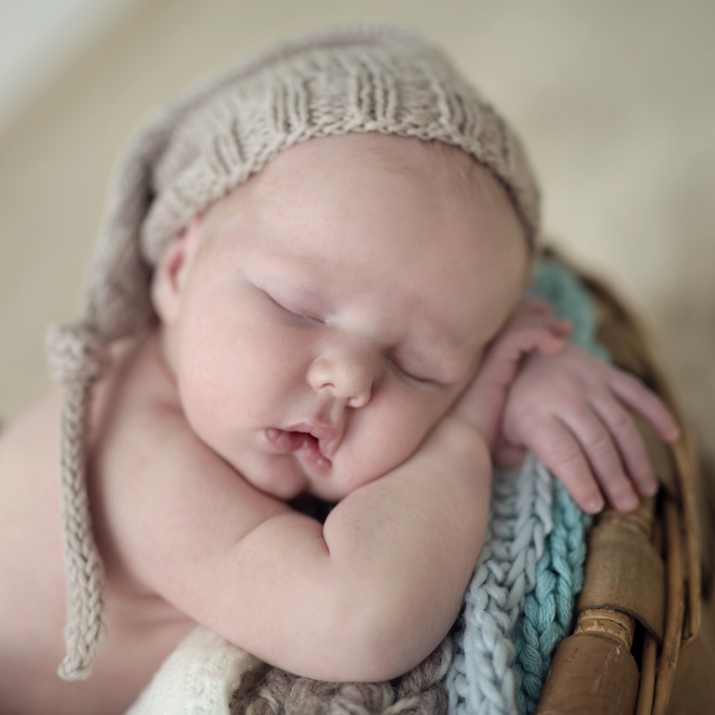 Маленький грудной ребенок спит в вязаной шапке