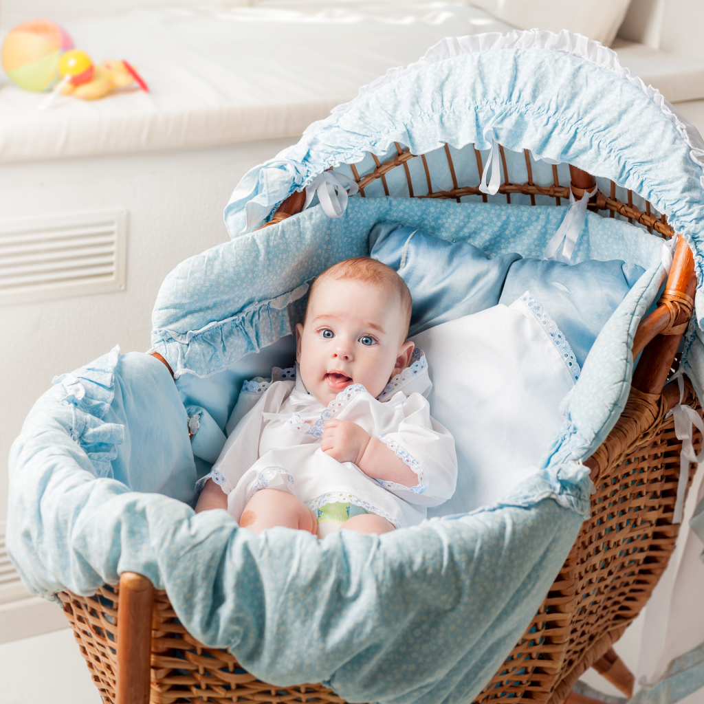 Маленький голубоглазый младенец в кроватке