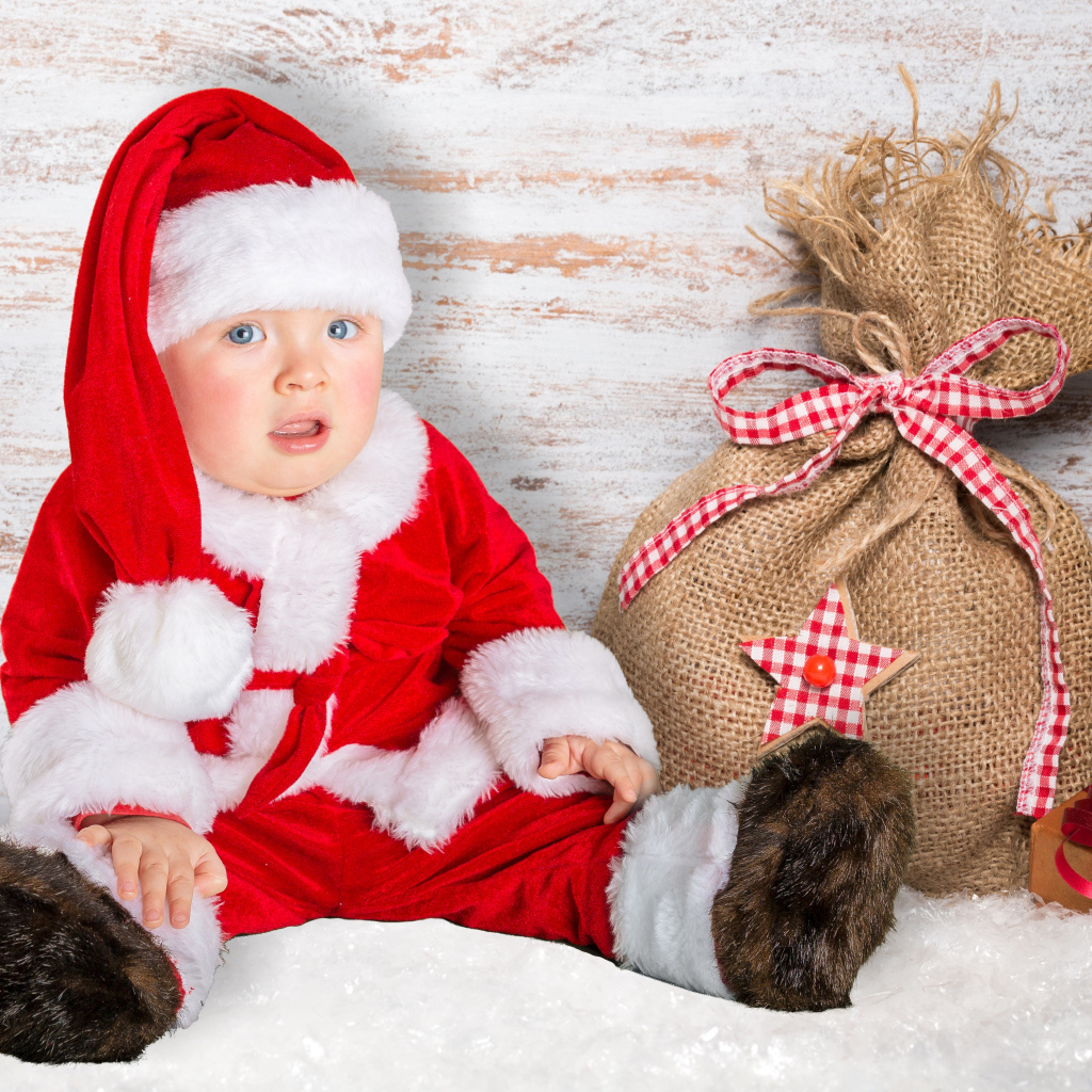 Маленький ребенок в костюме Санты с мешком