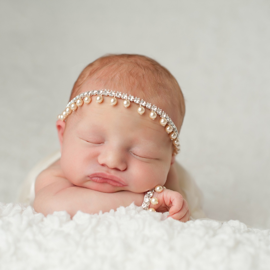 Маленький спящий грудной ребенок с красивым украшением на голове
