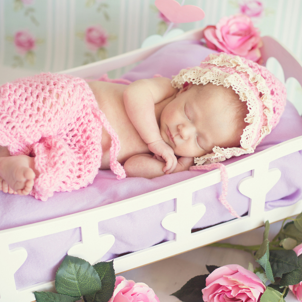 Милая спящая маленькая девочка в розовой кроватке