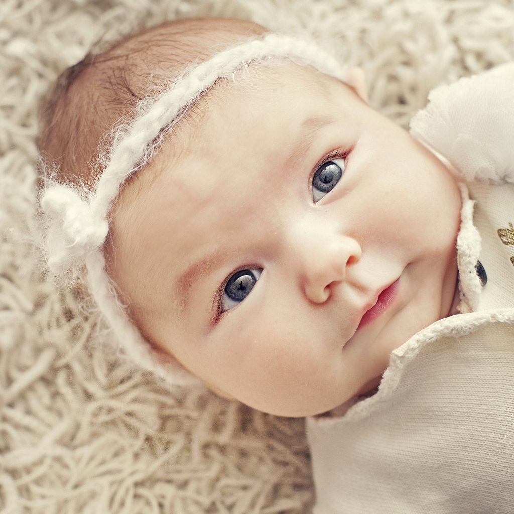 Красивая голубоглазая малышка с повязкой на голове