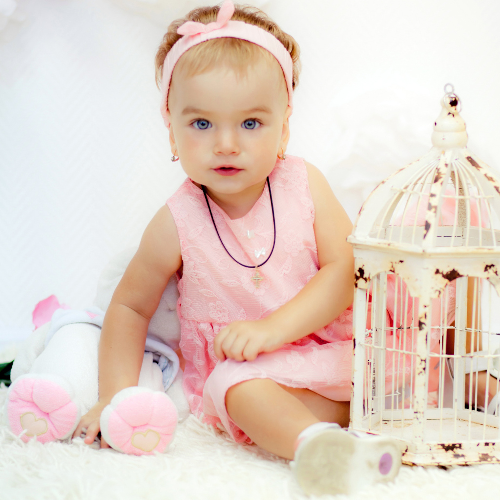 Красивая маленькая девочка в розовом платье с клеткой