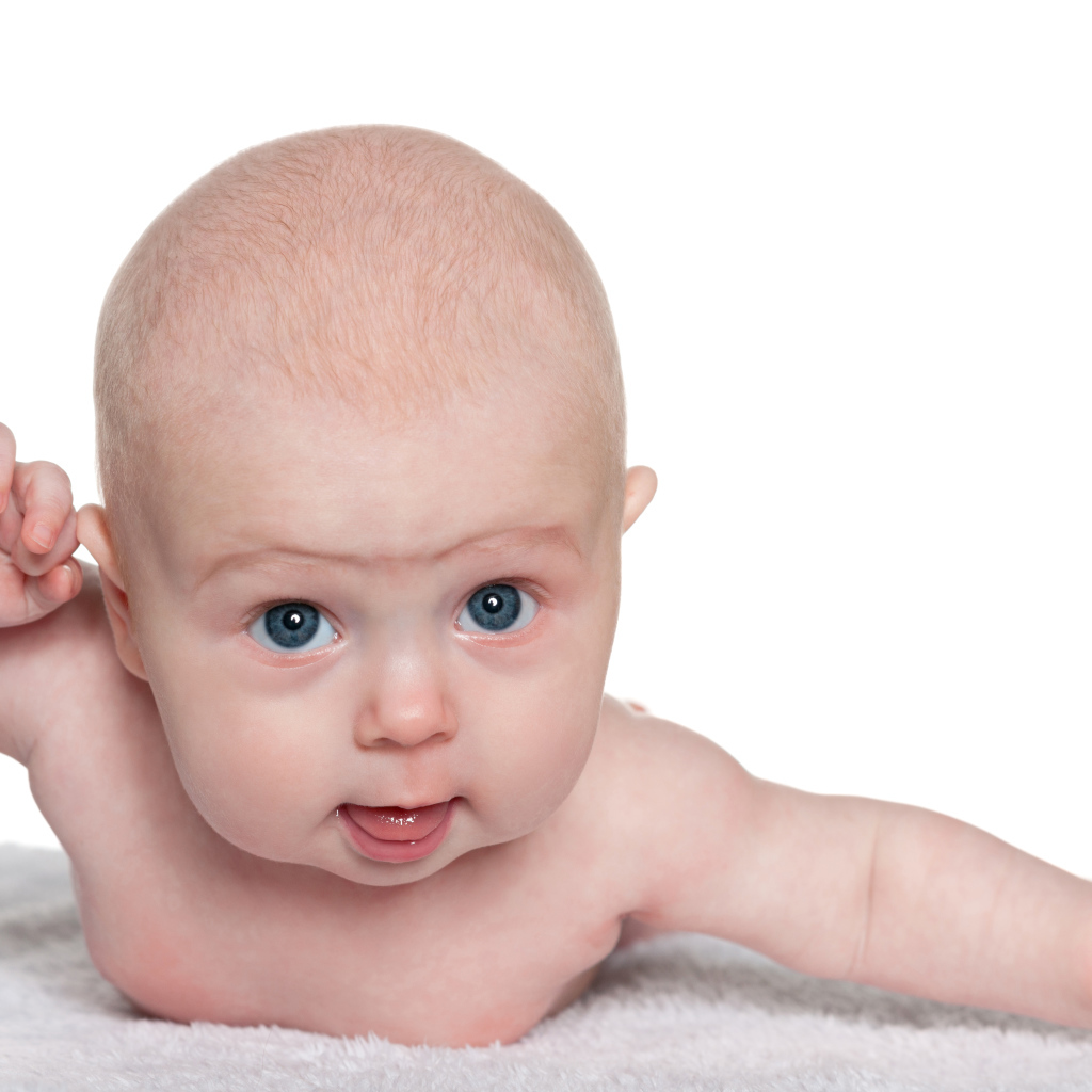 Голубоглазый малыш лежит на белом фоне