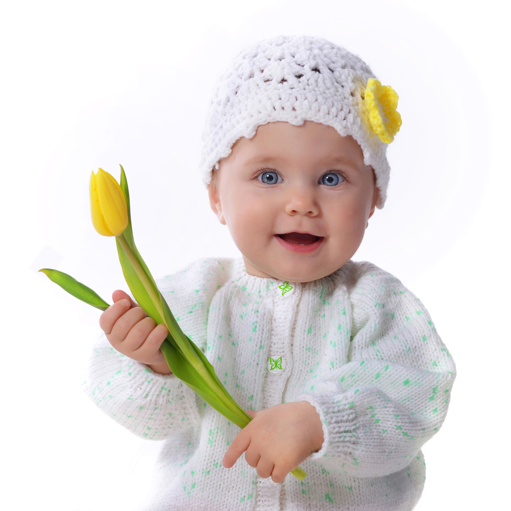 Голубоглазая маленькая девочка с желтым тюльпаном в руках