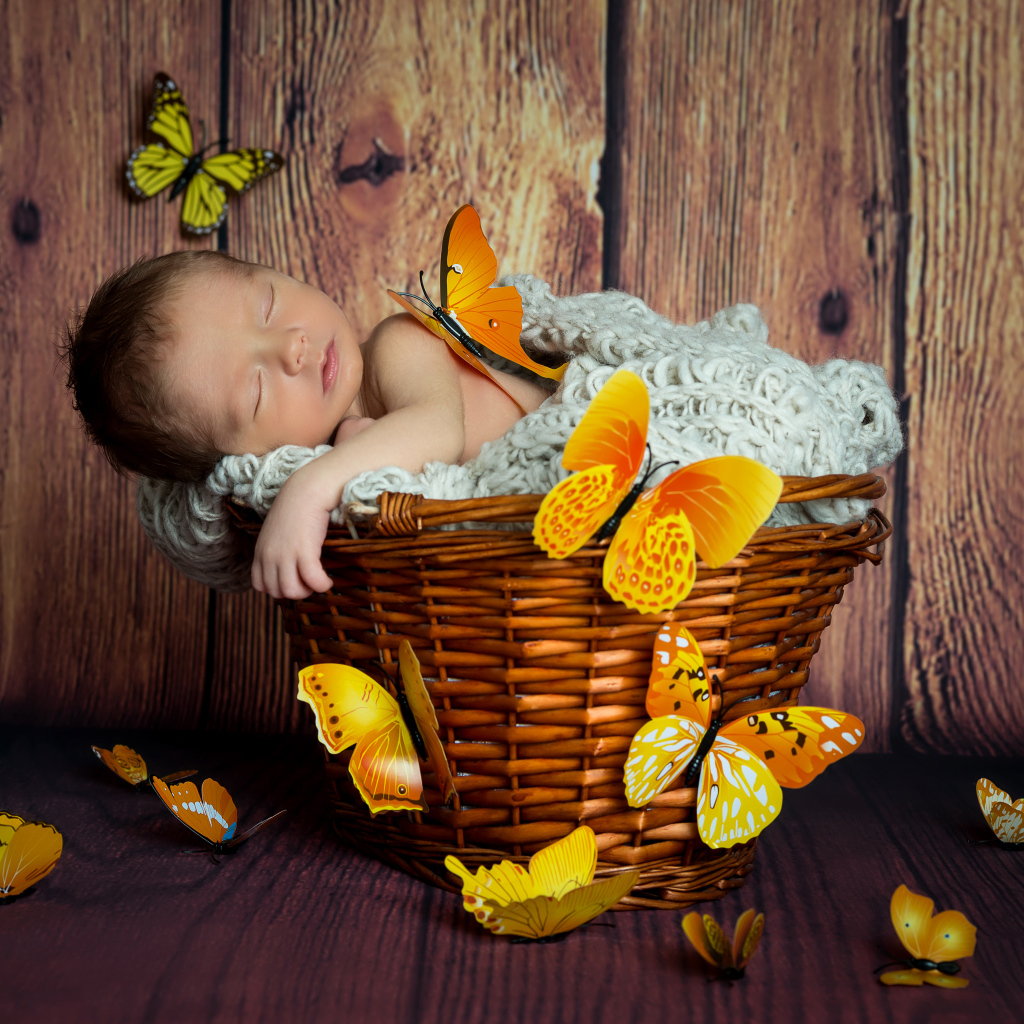 Милый спящий младенец в корзине с бабочками