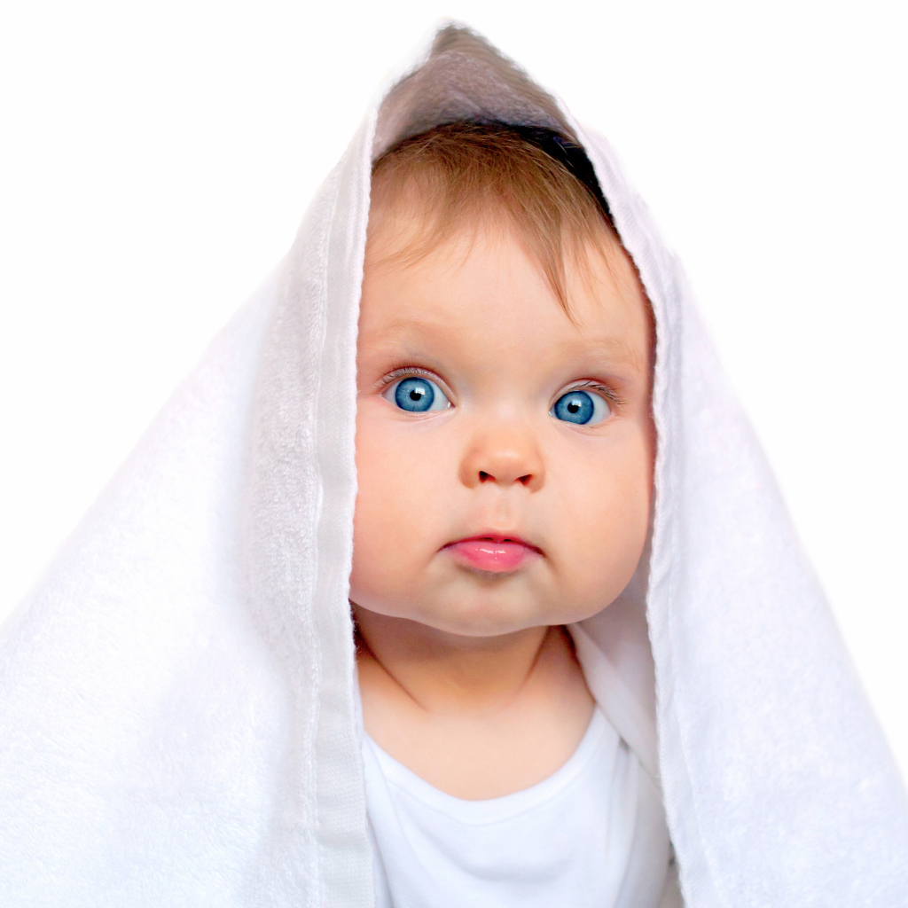Милый голубоглазый малыш с белом полотенце