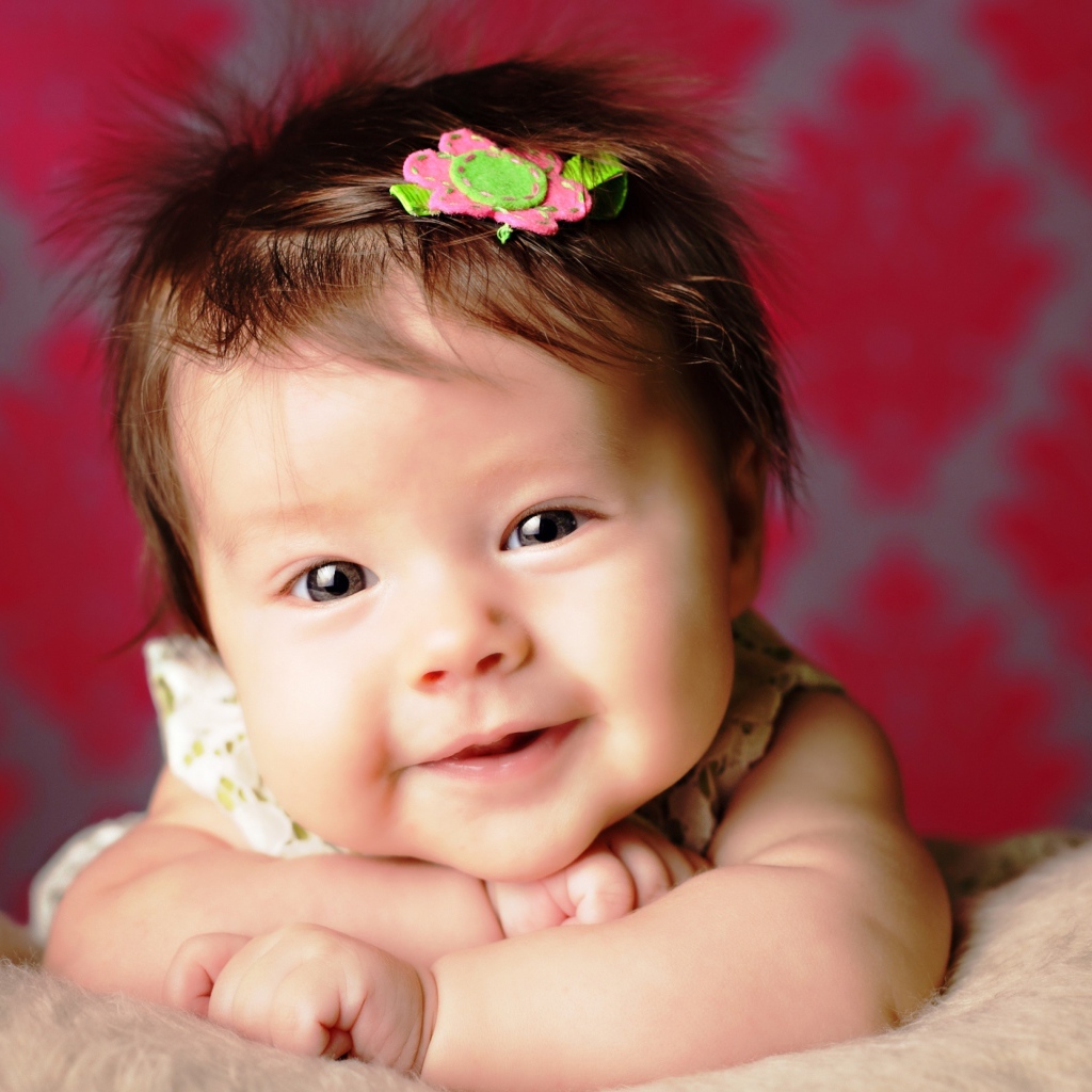 Милая маленькая девочка с цветком в волосах 