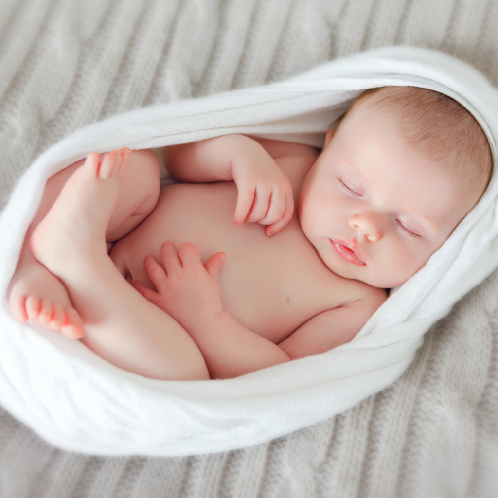 Милый спящий младенец в белом покрывале
