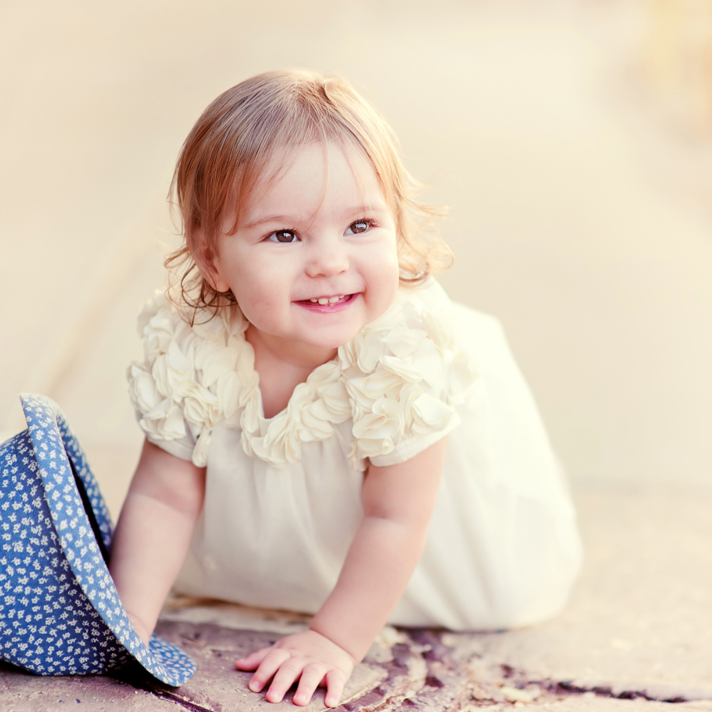 Милая улыбающаяся девочка в белом платье