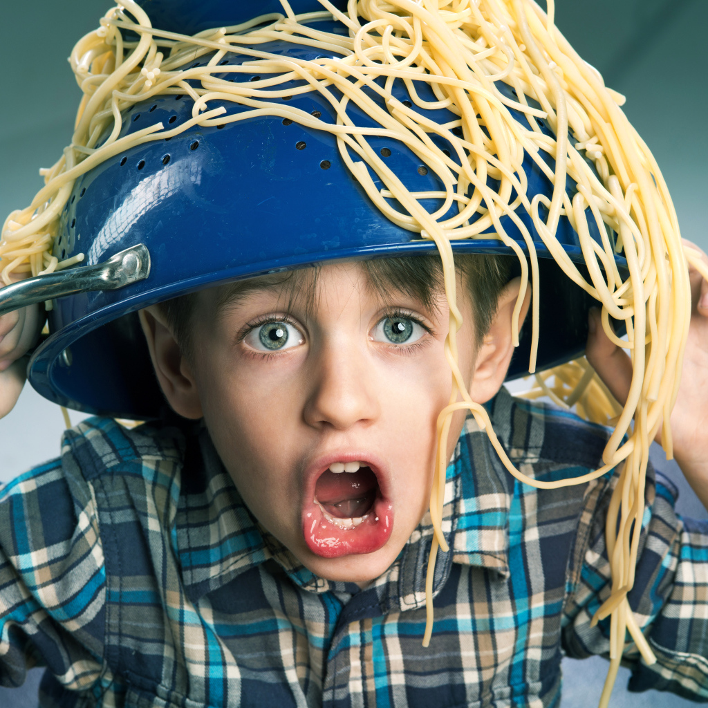Смешной мальчик со спагетти на голове