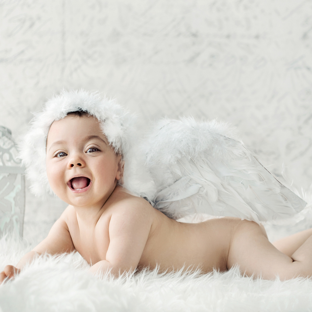 Забавный улыбающийся ребенок с крыльями ангела