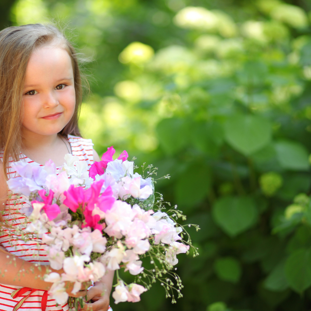 Русоволосая девочка с букетом цветов в руках